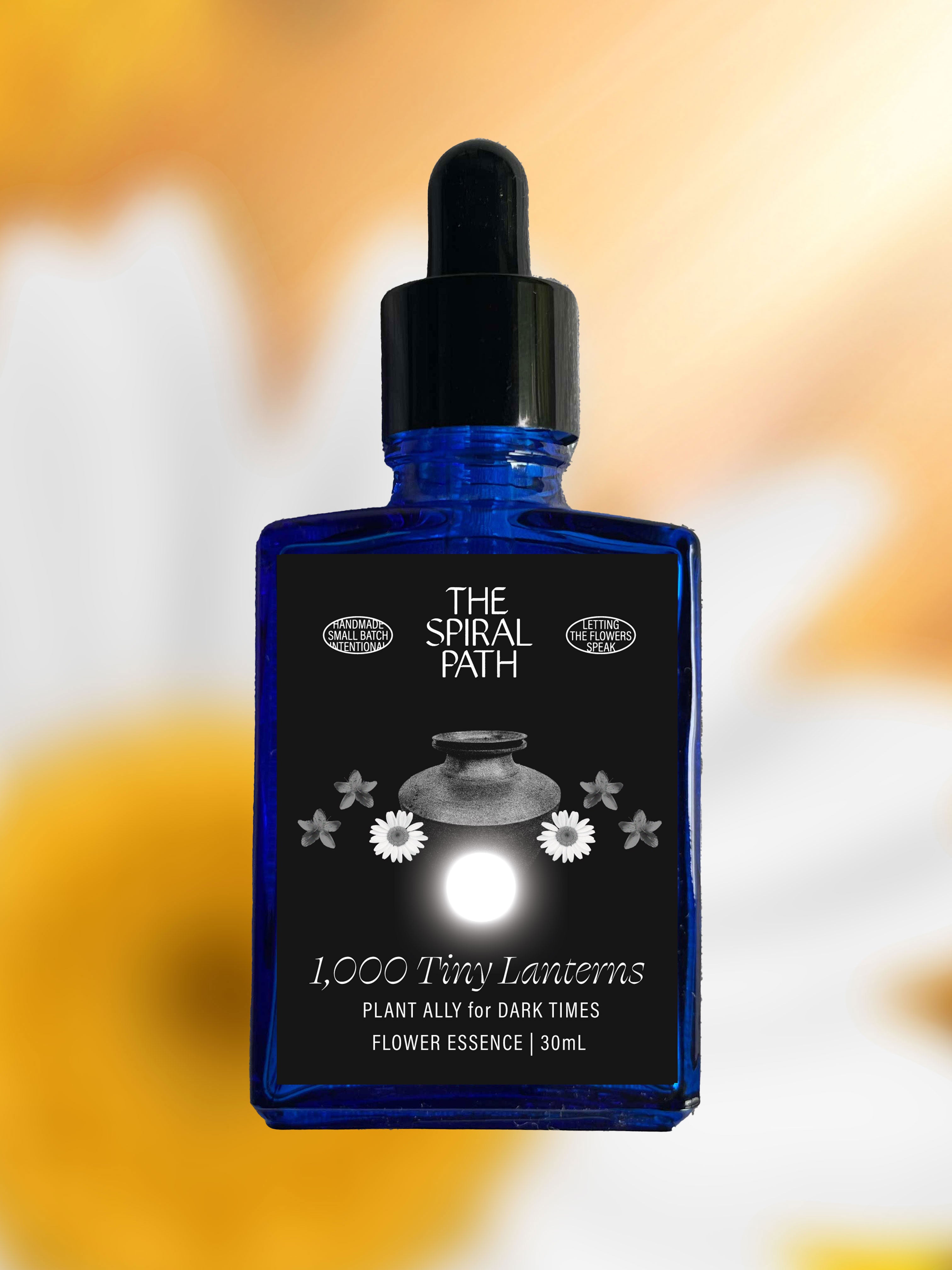 Small batch organic flower essence - feminine healing, 15mL, blue glass bottle with dropper. This essence supports emotional healing and is a sensitive medicine for sensitive people. 1,000 Tiny Lanterns flower essence is a plant ally for dark times. Saint John's Wort, Daisy, and light from the Summer Solstice.